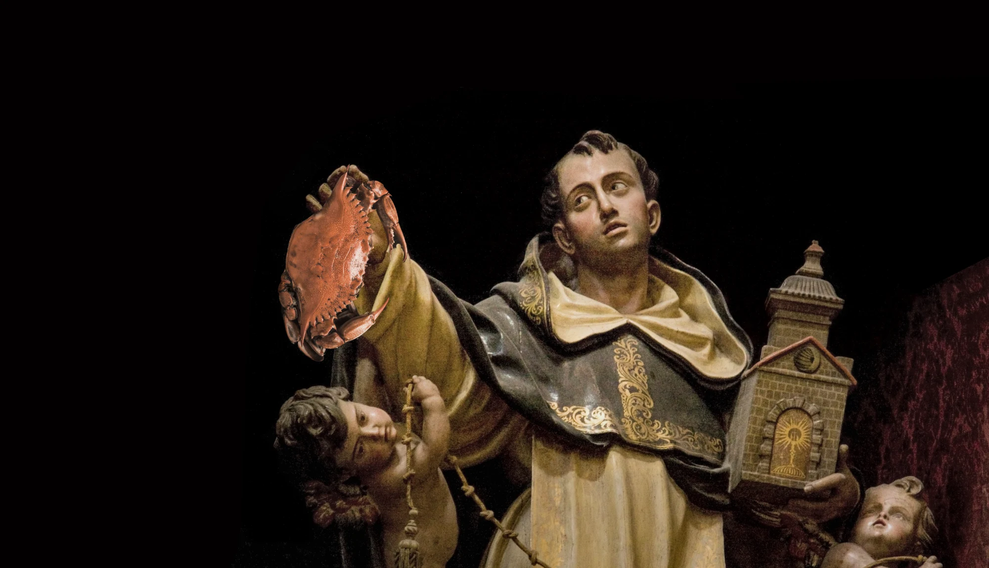 Un santo domenicano regge un granchio con la mano